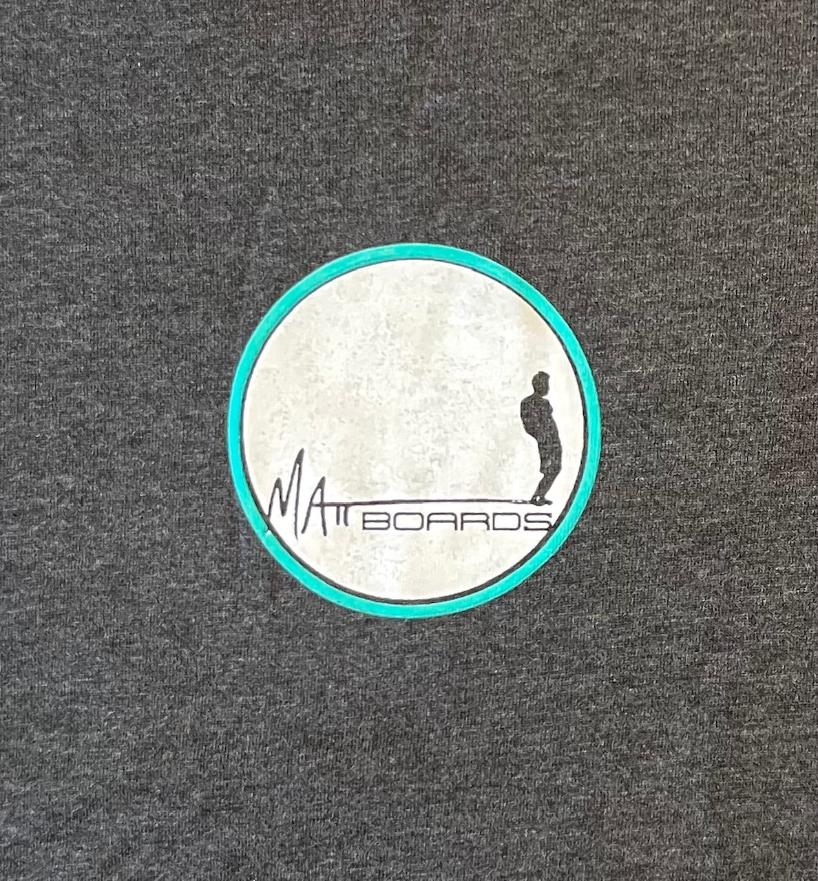 T-shirt logo detail on charcoal background