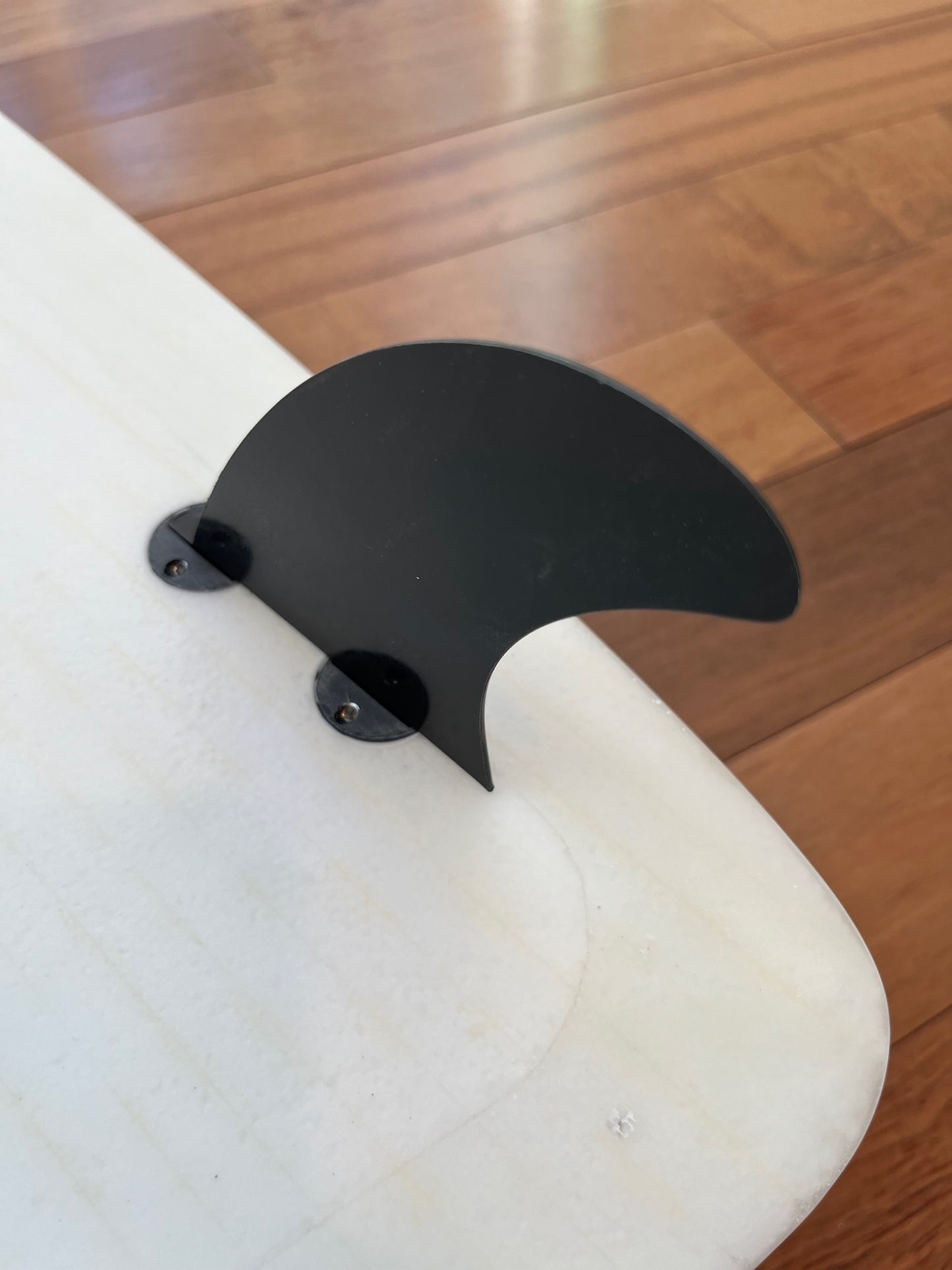 Close up of white surfboard showing detail of fin